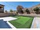 Spacious backyard featuring a putting green, patio, and a landscaped wall at 257 Elder View Dr, Las Vegas, NV 89138