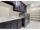 Laundry room complete with washer, dryer, sink, storage cabinets and shelving at 257 Elder View Dr, Las Vegas, NV 89138
