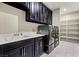 Modern laundry room featuring a sink, cabinets, and shelving at 257 Elder View Dr, Las Vegas, NV 89138