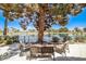 Serene back patio with comfortable seating, shaded by a mature tree, overlooking a peaceful lake at 2608 Port Of Call Dr, Las Vegas, NV 89128