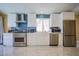 Bright kitchen with stainless steel appliances, white cabinetry, and blue backsplash at 2608 Port Of Call Dr, Las Vegas, NV 89128