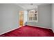 Bedroom with red carpet and view into ensuite bathroom and arched window with blinds at 2622 Rimpacific Cir, Las Vegas, NV 89146