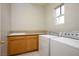 Laundry room featuring a utility sink, tile floors, granite counters and a window for natural light at 2622 Rimpacific Cir, Las Vegas, NV 89146