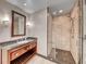 Bathroom with granite countertop, wood cabinetry, walk-in shower, decorative light fixtures, and coordinating hardware at 2700 Las Vegas Blvd # 3501, Las Vegas, NV 89109