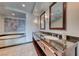 Luxurious bathroom featuring dual sinks, a vanity with granite countertop, and a soaking tub with marble trim at 2700 Las Vegas Blvd # 3501, Las Vegas, NV 89109