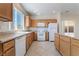 Modern kitchen featuring a white dishwasher, countertops, white appliances, wood cabinetry, and sink with window at 2739 Cramond St, Henderson, NV 89044