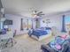 Cozy bedroom featuring a ceiling fan, carpet floors, large windows, and a queen-size bed with blue covers at 2743 Peekskill Ave, Henderson, NV 89052