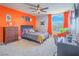 bedroom featuring a ceiling fan, a window with orange curtains, a dresser, and a workspace at 2743 Peekskill Ave, Henderson, NV 89052