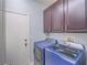 Well-equipped laundry room with modern washer and dryer units and dark cabinets at 2743 Peekskill Ave, Henderson, NV 89052