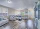 Bright living room with a large sectional sofa, stylish decor, and hardwood floors at 2743 Peekskill Ave, Henderson, NV 89052