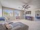 Large carpeted living room featuring a grey sofa, plenty of natural light, and access to the main bedroom at 2743 Peekskill Ave, Henderson, NV 89052