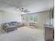 Huge carpeted living room with sofa, fan, and many windows providing lots of natural light at 2743 Peekskill Ave, Henderson, NV 89052