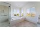 Bright bathroom with a soaking tub, glass shower, and shuttered windows at 2894 Carmelo Dr, Henderson, NV 89052