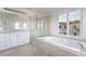 Bathroom with a large soaking tub, glass shower, and white cabinetry at 2894 Carmelo Dr, Henderson, NV 89052