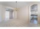 Elegant dining room with chandelier, archways to living spaces, and a glimpse of the kitchen at 2894 Carmelo Dr, Henderson, NV 89052