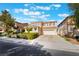 Two-story home with a two-car garage, well-manicured lawn and blue sky at 2894 Carmelo Dr, Henderson, NV 89052