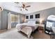 Calm bedroom with a plush rug, ceiling fan, neutral colors, and natural light from the large window at 3103 Sunrise Cove Ave, North Las Vegas, NV 89031