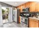 Functional kitchen with stainless steel appliances, wood cabinets, and sliding door access to the backyard at 3103 Sunrise Cove Ave, North Las Vegas, NV 89031