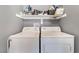 Functional laundry room with a washer, dryer, and storage shelves at 3103 Sunrise Cove Ave, North Las Vegas, NV 89031