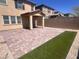 This backyard features a brick patio, small strip of artificial turf, and string lights at 3481 Bradano Ln, Henderson, NV 89044