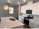 Modern kitchen with a marble-patterned island countertop, bright lighting, and sleek white cabinetry at 3481 Bradano Ln, Henderson, NV 89044