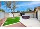 Secluded backyard with a hot tub, artificial turf, and unique landscaping at 3597 Cochise Ln, Las Vegas, NV 89169