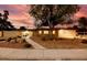 Charming single-story home with desert landscaping and a walkway leading to a bright yellow front door during dusk at 3597 Cochise Ln, Las Vegas, NV 89169