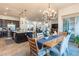 Open-concept dining room with chandelier, wood table, and access to the kitchen with a large island at 408 Middlestone Ave, Henderson, NV 89011