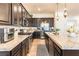 A kitchen featuring granite countertops, stainless steel appliances, tile floors, and dark brown cabinets at 408 Middlestone Ave, Henderson, NV 89011