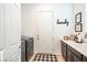 This laundry room offers a sink, cabinets, washer, dryer, and decor, and also a door leading to the outside at 408 Middlestone Ave, Henderson, NV 89011