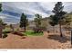 Spacious gravel backyard features a tranquil seating area with mature trees and mountain views at 45 Maleena Mesa St # 1113, Henderson, NV 89074