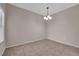 This dining room features neutral walls, a chandelier, tile floors and bright light from the window at 45 Maleena Mesa St # 1113, Henderson, NV 89074