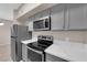 Modern kitchen features stainless appliances, gray cabinets, and stone countertops at 45 Maleena Mesa St # 1113, Henderson, NV 89074