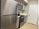 Modern kitchen with stainless steel appliances, light gray cabinets, and tile flooring at 45 Maleena Mesa St # 1113, Henderson, NV 89074