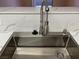 Close up view of a deep kitchen sink with a modern faucet and white countertops at 45 Maleena Mesa St # 1113, Henderson, NV 89074
