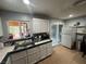 Functional kitchen with white cabinets, tiled countertops, and a convenient sliding glass door at 4825 E Monroe Ave, Las Vegas, NV 89110