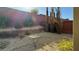Desert landscaping in the backyard with a tall brick wall and thin, tall trees at 5615 Oak Bend Dr, Las Vegas, NV 89135