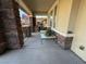 Relaxing covered front porch featuring stone pillars, ample seating, and outdoor decor at 5615 Oak Bend Dr, Las Vegas, NV 89135