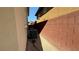 Narrow side yard with beige stucco siding, brick wall, and the home's A/C units at 5615 Oak Bend Dr, Las Vegas, NV 89135