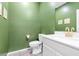 Stylish bathroom with a white vanity, green walls, and modern fixtures at 6239 Milford Sound St, Las Vegas, NV 89148