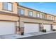 Townhouse garages showcasing ample parking space and modern design against a blue sky at 6239 Milford Sound St, Las Vegas, NV 89148