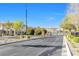 View of a well-maintained street with landscaped medians leading to a gated entrance at 6239 Milford Sound St, Las Vegas, NV 89148