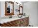 Bathroom features a double vanity with granite countertop, wooden cabinets, and modern fixtures at 6304 Peppermill Dr, Las Vegas, NV 89146