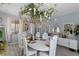 A dining room features a long white table with flowers hanging from the ceiling and decorative mirrors at 6620 Macdoogle St, Las Vegas, NV 89166