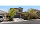 Charming two-story home with desert landscaping, a driveway, and an attached garage at 6620 Macdoogle St, Las Vegas, NV 89166
