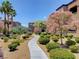 Charming courtyard with winding sidewalks, mature trees, colorful bushes, and well-maintained landscaping at 6650 W Warm Springs Rd # 2173, Las Vegas, NV 89118