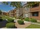 Exterior view of well-maintained apartment buildings with lush green lawns, mature trees, and manicured landscaping at 6650 W Warm Springs Rd # 2173, Las Vegas, NV 89118