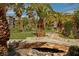 Lush community landscape featuring a stone bridge over a dry creek bed, palm trees, and well-maintained lawns at 6650 W Warm Springs Rd # 2173, Las Vegas, NV 89118