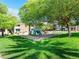 Community playground with slides, climbing structures, and a wood chip ground cover, surrounded by green lawns at 6650 W Warm Springs Rd # 2173, Las Vegas, NV 89118
