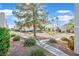 Exterior view of residential buildings featuring natural landscaping, mature trees and walkway at 6800 E Lake Mead Blvd # 2050, Las Vegas, NV 89156